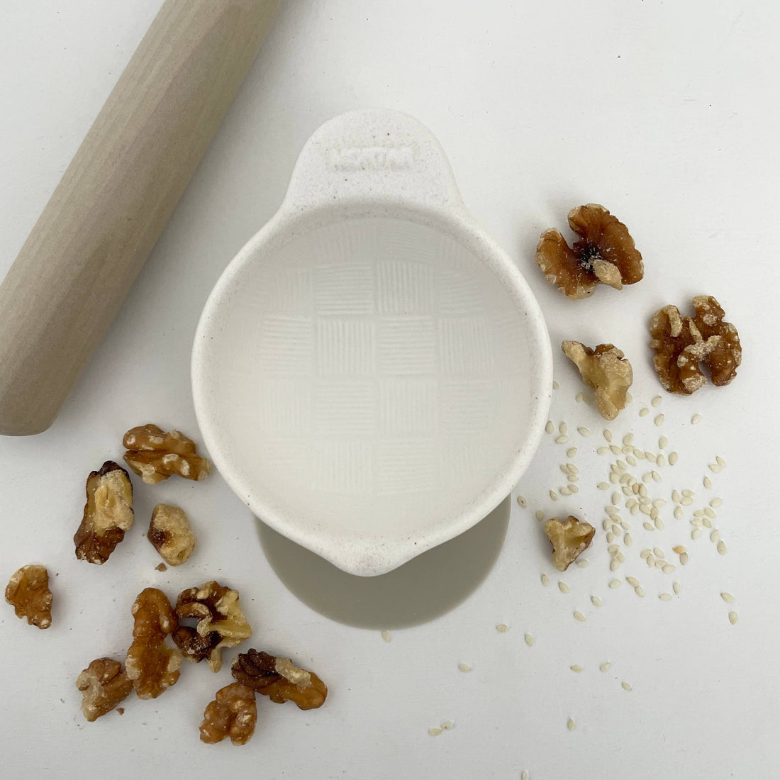 Fort & Field Japanese Ceramic Mortar, white porcelain with basketweave texture, top-down flat lay with walnuts, sesame…