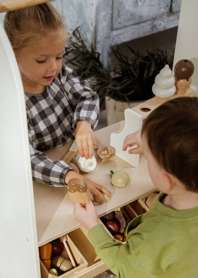 
                    
                      Children playing with Wooden Ice Cream Stand set, natural wood popsicle, white ice cream, painted fruit, view of hands.
                    
                  