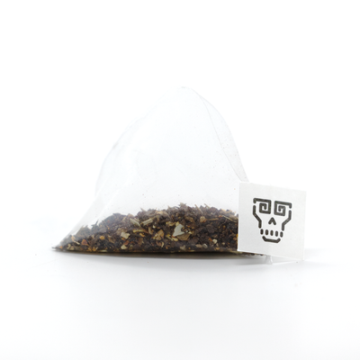 
                    
                      Gochujang Chai tea bag, pyramid mesh bag with visible dark tea leaves and spices, close-up of white tag with black skull…
                    
                  