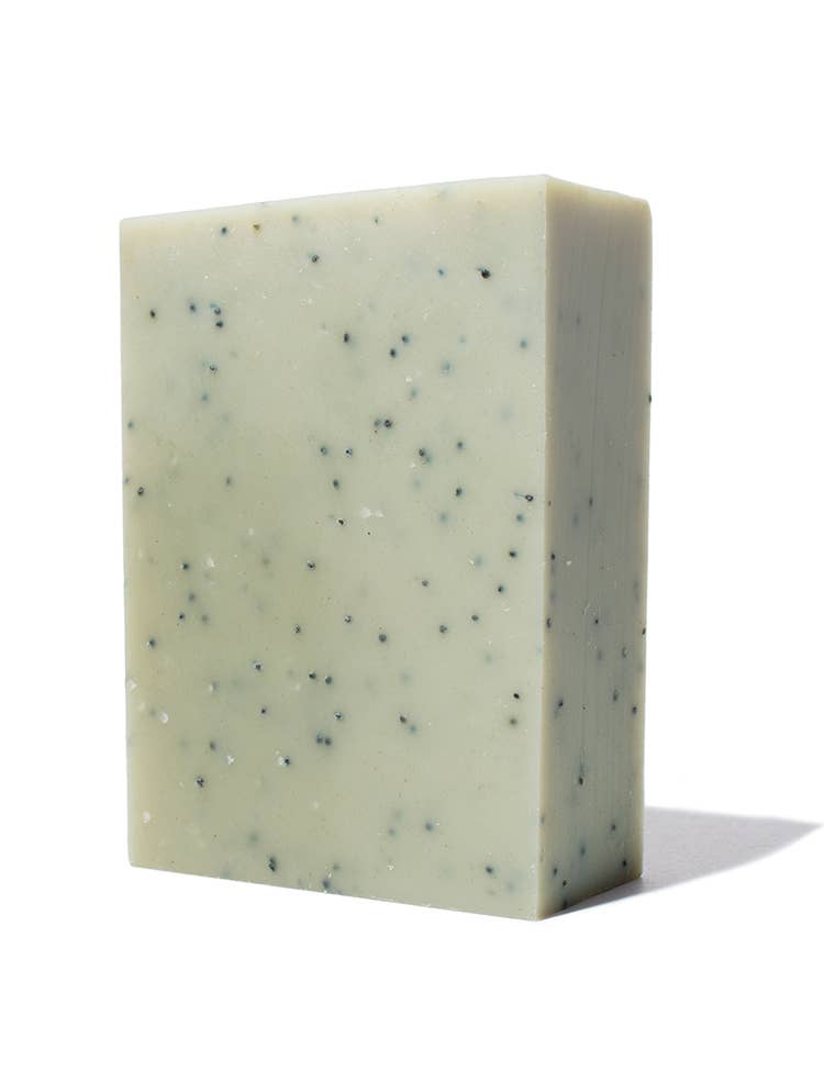 Basil Bar Soap, pale green with visible dark poppy seeds, angled standing view on white.