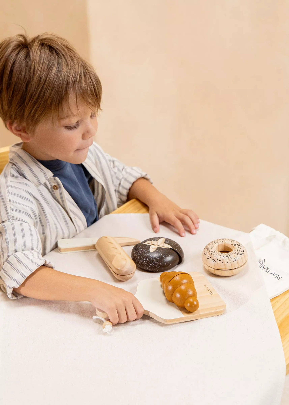 Wooden Bakery Set play food toys, child playing with brown wood croissant on natural wood cutting board, baguette, bagel.