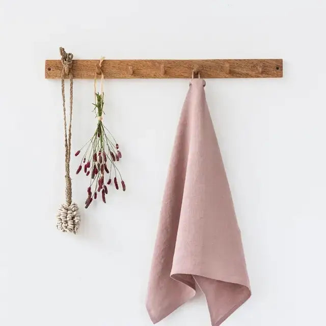 Premium Linen Tea Towel in blush pink, 100% linen, hanging folded on a wooden peg rail.