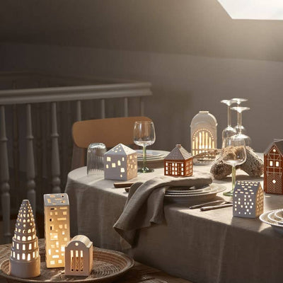 
                    
                      Urbania Town House ceramic candle holder, white, illuminated on a dining table, creating a cozy ambiance with other Urbania…
                    
                  