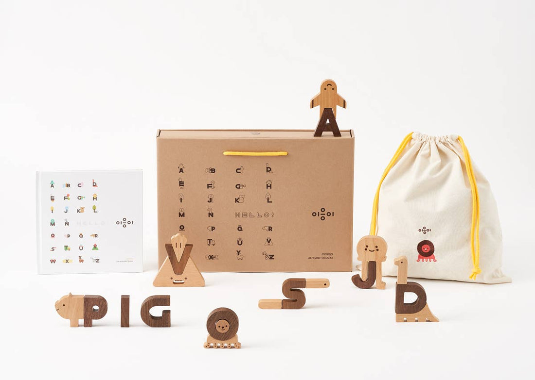 Alphabet Play Blocks set with beech and walnut wood letters forming PIG. Includes kraft box, white booklet, and cotton…