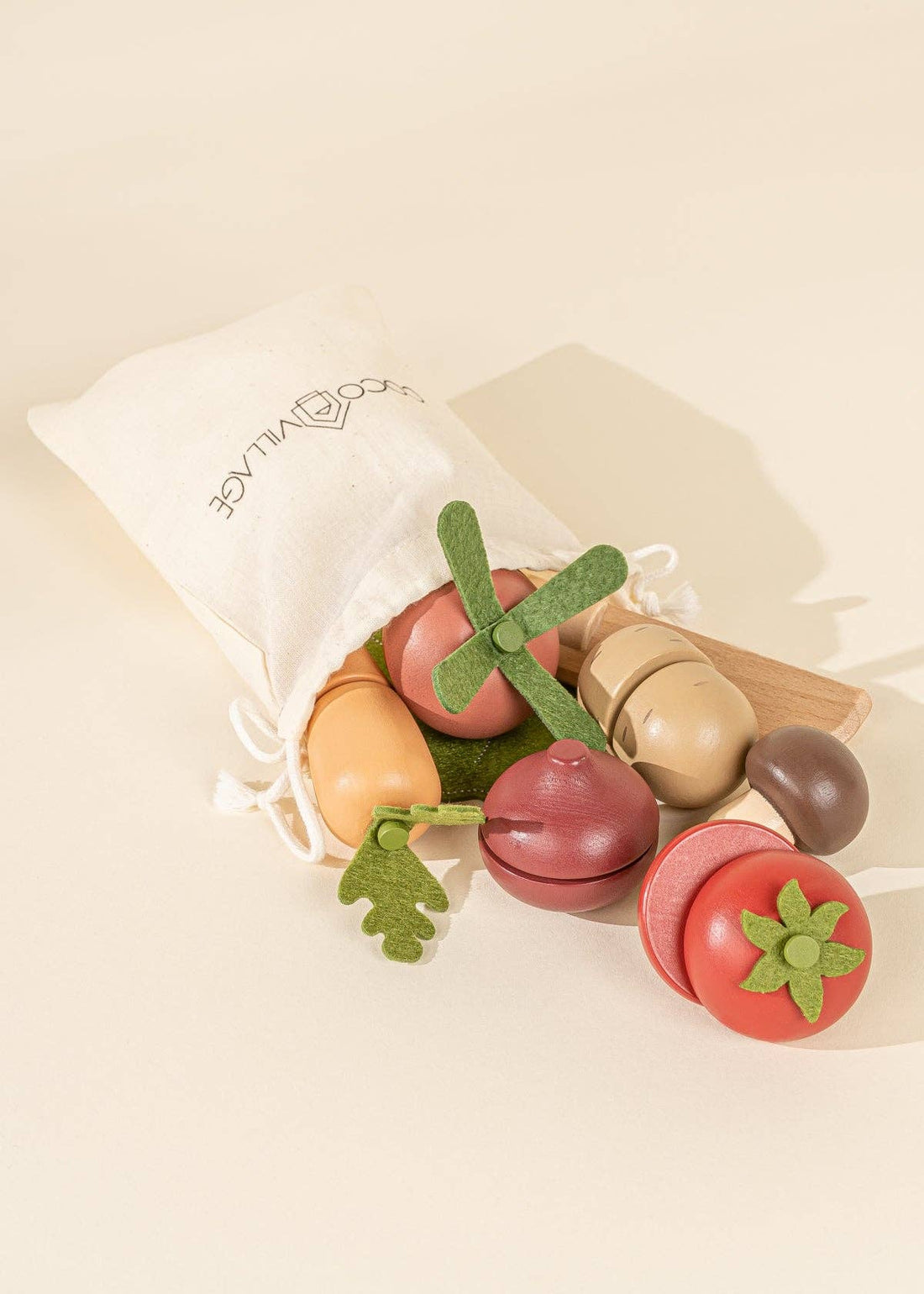 Wooden Vegetables Playset, red, tan, & brown wood vegetables with green felt leaves spilling from cream fabric bag.