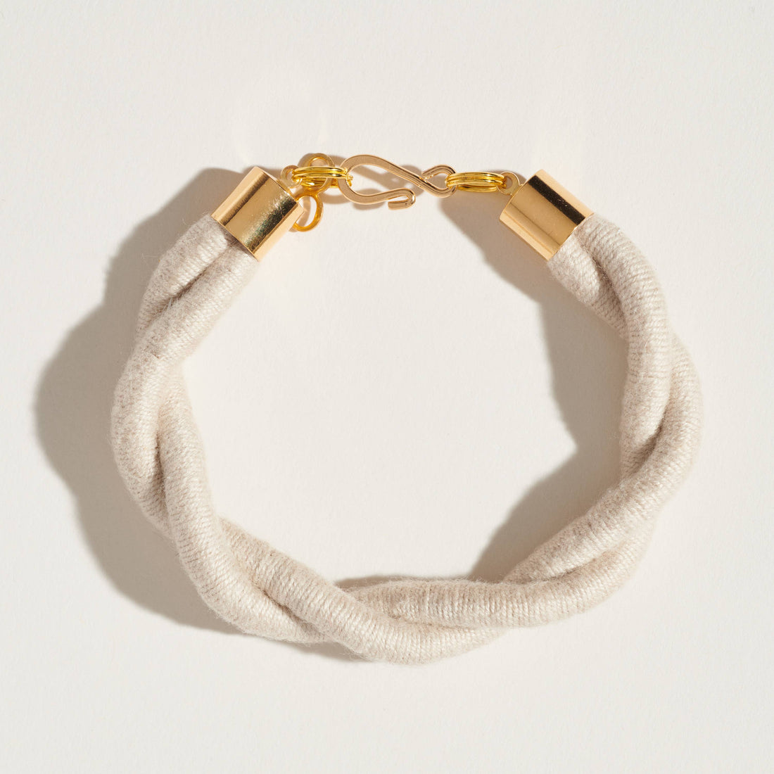 Hemp Twist bracelet, twisted light natural fiber cording, detailed gold-toned brass S-clasp and end caps, flat lay.