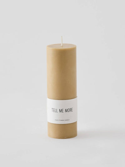 
                    
                      Luna pure stearin candle, beige cylindrical, with 'Tell Me More' brand label centered on it, front view.
                    
                  