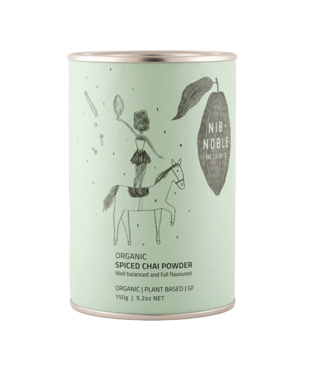 Nib + Noble Organic Spiced Chai Powder, light mint green tin with whimsical illustration, front view on white.