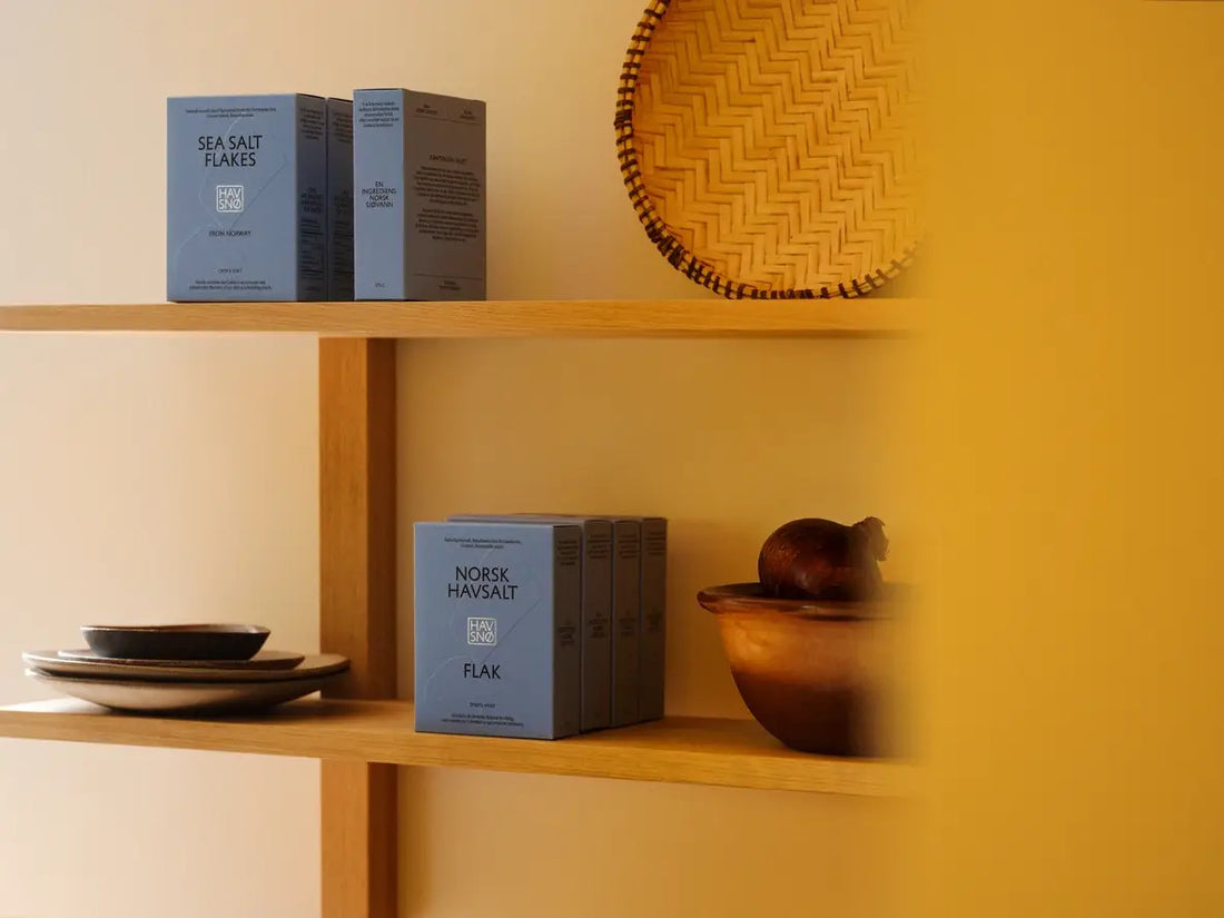 Havsnø Norwegian Sea Salt Flakes, light blue-gray boxes, multiple packs displayed on wooden shelves.
