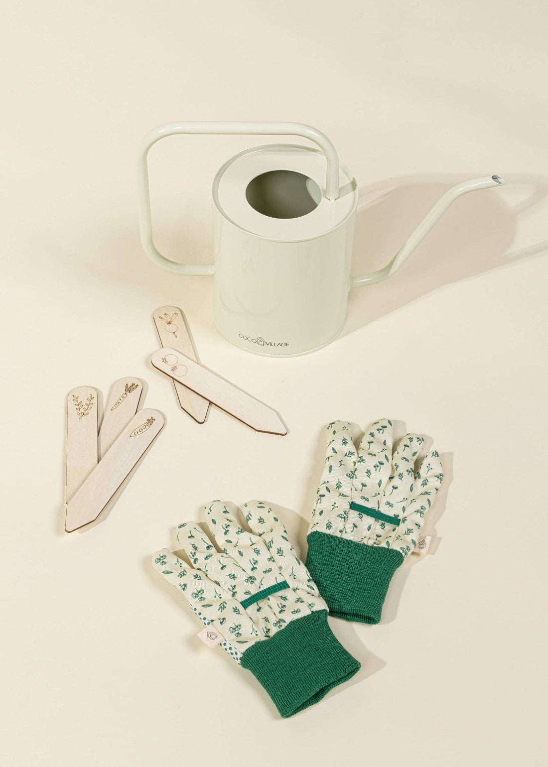 Gardening Tools Playset for kids, light green metal watering can, green patterned gloves, and wood plant markers, flat lay…