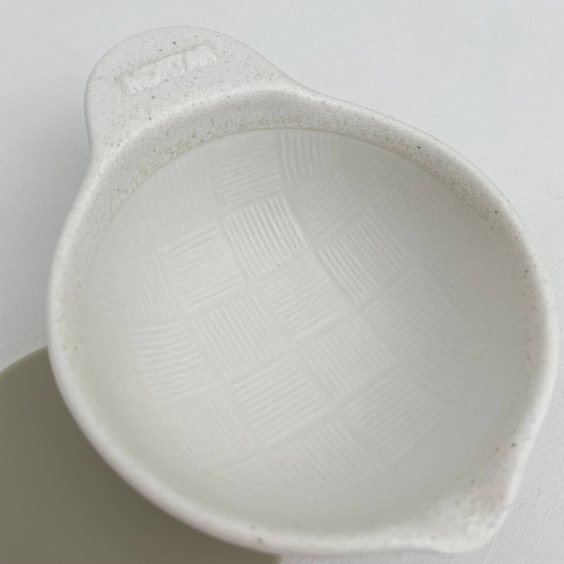 Japanese Ceramic Mortar, white speckled porcelain, angled close-up view showing ridged grinding pattern inside.