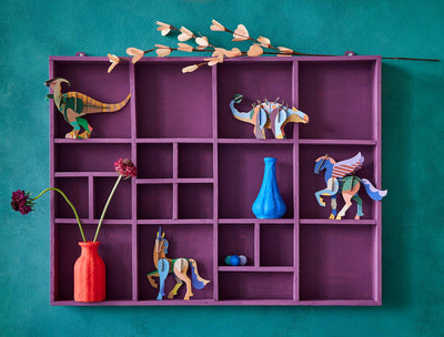 
                    
                      3D Unicorn craft kit assembled, colorful recycled cardboard, displayed standing in a purple cubby shelf.
                    
                  