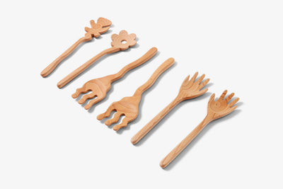 
                    
                      Areaware Serving Friends wooden serving utensils, set of six playful beech wood shapes, flat lay on white.
                    
                  