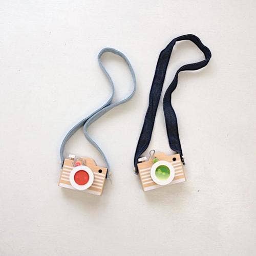 Two Kaleidoscope Play Cameras: beechwood toys with red and green acrylic lenses, light blue and dark blue straps, flat lay.