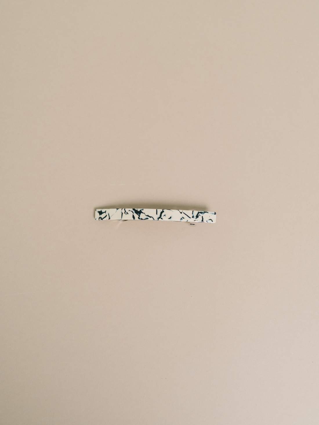 Coco Cream hair clip, cream and dark marbled cellulose acetate, flat lay showing metal barrette clip.