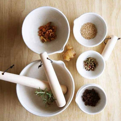 
                    
                      Japanese Hinoki Cypress Wood Surikogi pestles, light natural wood, flat lay in mortar bowl with fresh rosemary.
                    
                  