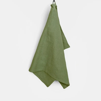 
                    
                      Green linen tea towel hanging from a hook, showcasing natural texture and soft drape.
                    
                  