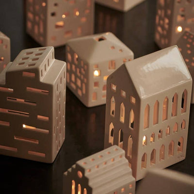 
                    
                      Urbania Church ceramic candle holder, off-white dolomite, displayed with other glowing house-shaped holders.
                    
                  