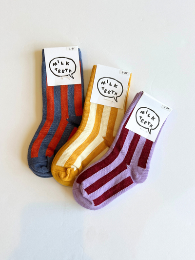 
                    
                      Stripe cotton kids socks in blue/orange, yellow/cream, and purple/burgundy, three folded pairs flat lay with size 1-3Y tags.
                    
                  