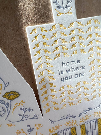 
                    
                      Home Is Where You Are Cut House Card, close-up showing letterpress 'home is where you are' text, raised yellow leaf design…
                    
                  