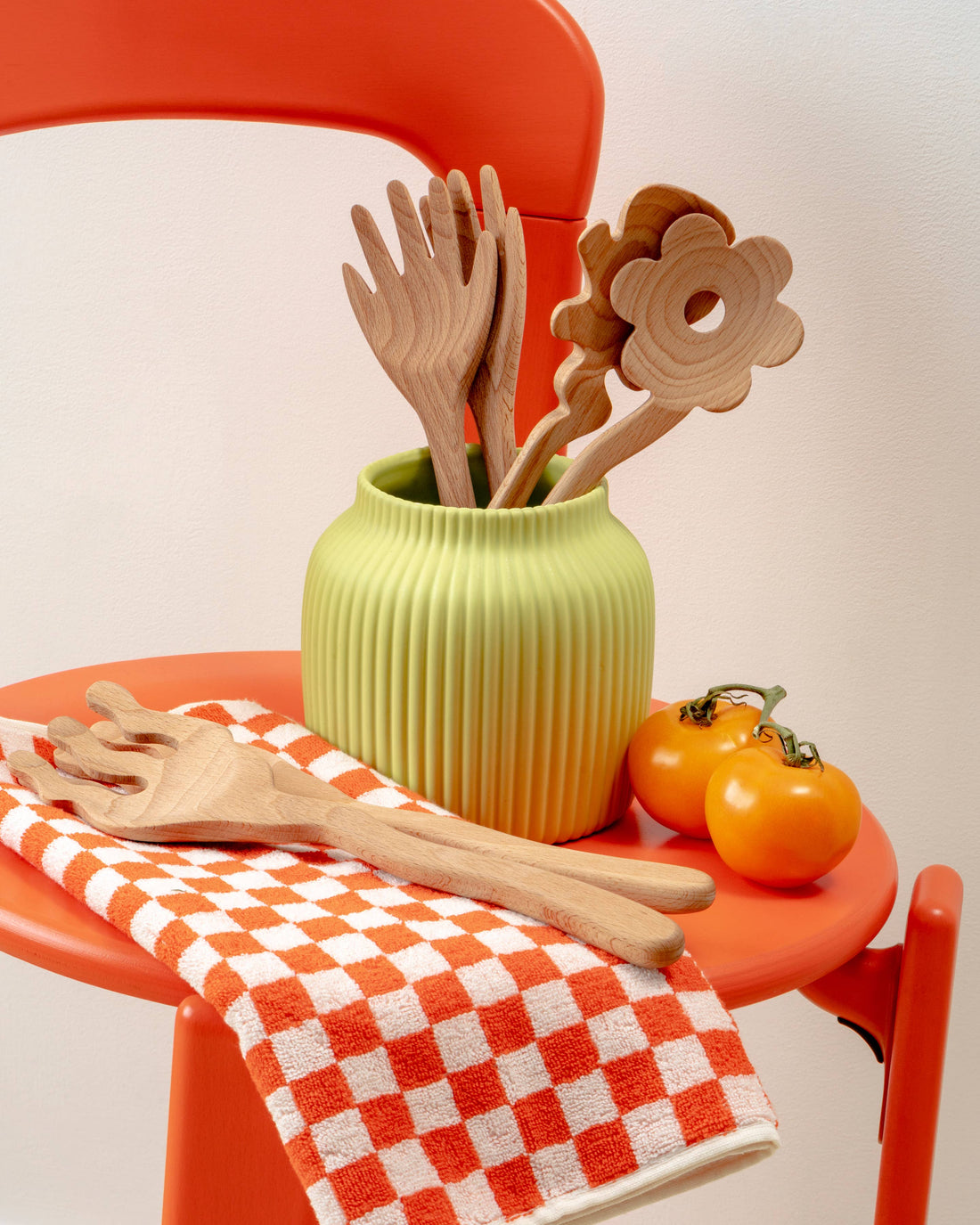 Serving Friends beech wood serving utensils, hand-shaped server on orange checkered towel, with flower and wavy servers in a…