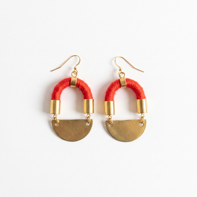 
                    
                      Sasha Half Moon earrings, red yarn-wrapped cording with brass moon pendants and gold-plated hardware, flat lay pair on white.
                    
                  