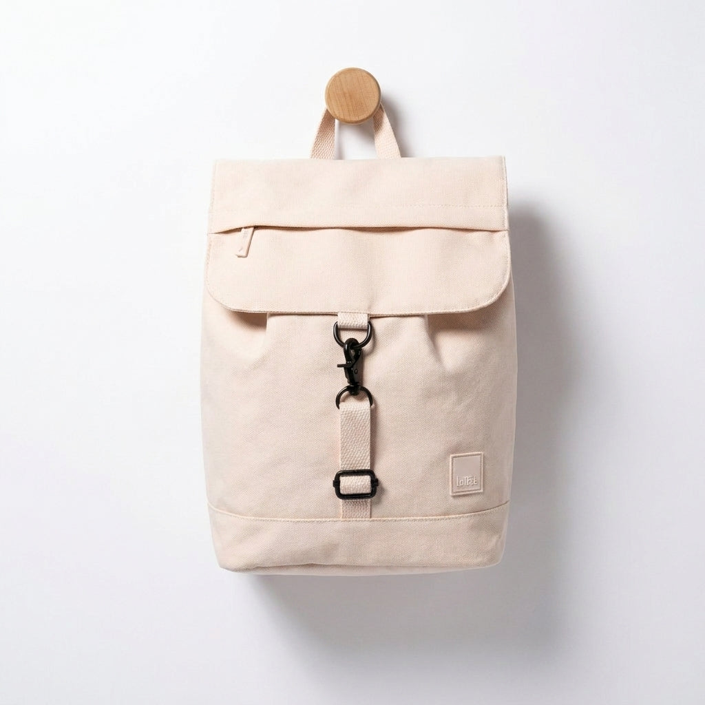 Lefrik Kaut Mini Ecru Backpack studio product photo hanging from a wooden wall hook on a neutral off-white background