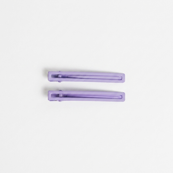 NAT + NOOR Leia alligator hair clips, a pair of solid lavender hair clips, flat lay on white.