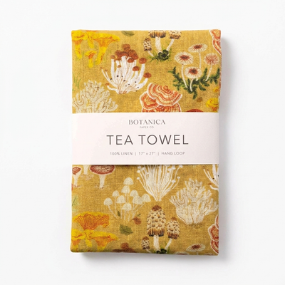 
                    
                      Botanica Paper Co. Mushrooms linen tea towel, yellow with colorful mushroom pattern, neatly folded with brand band, front on…
                    
                  