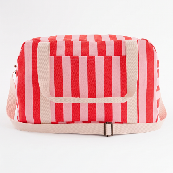 Rose in April Raphael Weekend / Diaper Bag - (Tomato + Candy Pink) studio product photo hanging from a wooden wall hook on a…