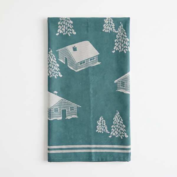 Sylvie Thiriez Torchon Jacquard Coeur Vallée tea towel, blue cotton with white cabins & pine trees jacquard, folded front…