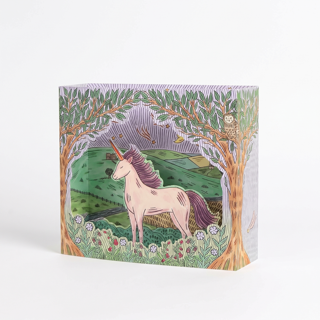 Twilight Unicorn die-cut greeting card, featuring a pink unicorn illustration, green landscape, purple sky, standing angled…