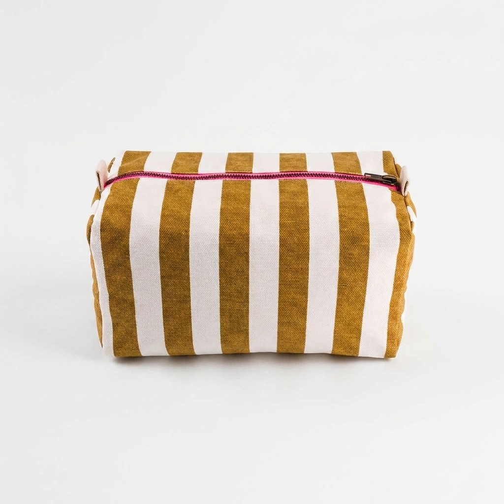 Rose in April Vic Toiletry Bag - Caramel studio product photo hanging from a wooden wall hook on a neutral off-white…