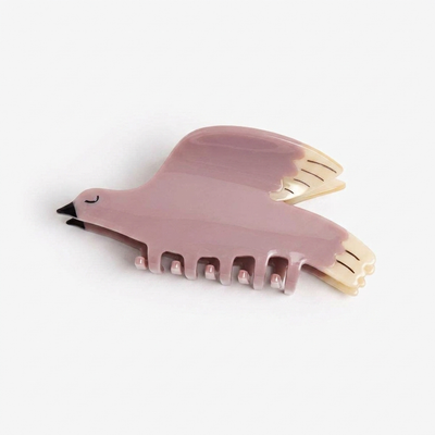 
                    
                      Winona Irene White Wing Dove Hair Claw, lilac cellulose acetate with cream wings and black beak, flat lay on white.
                    
                  